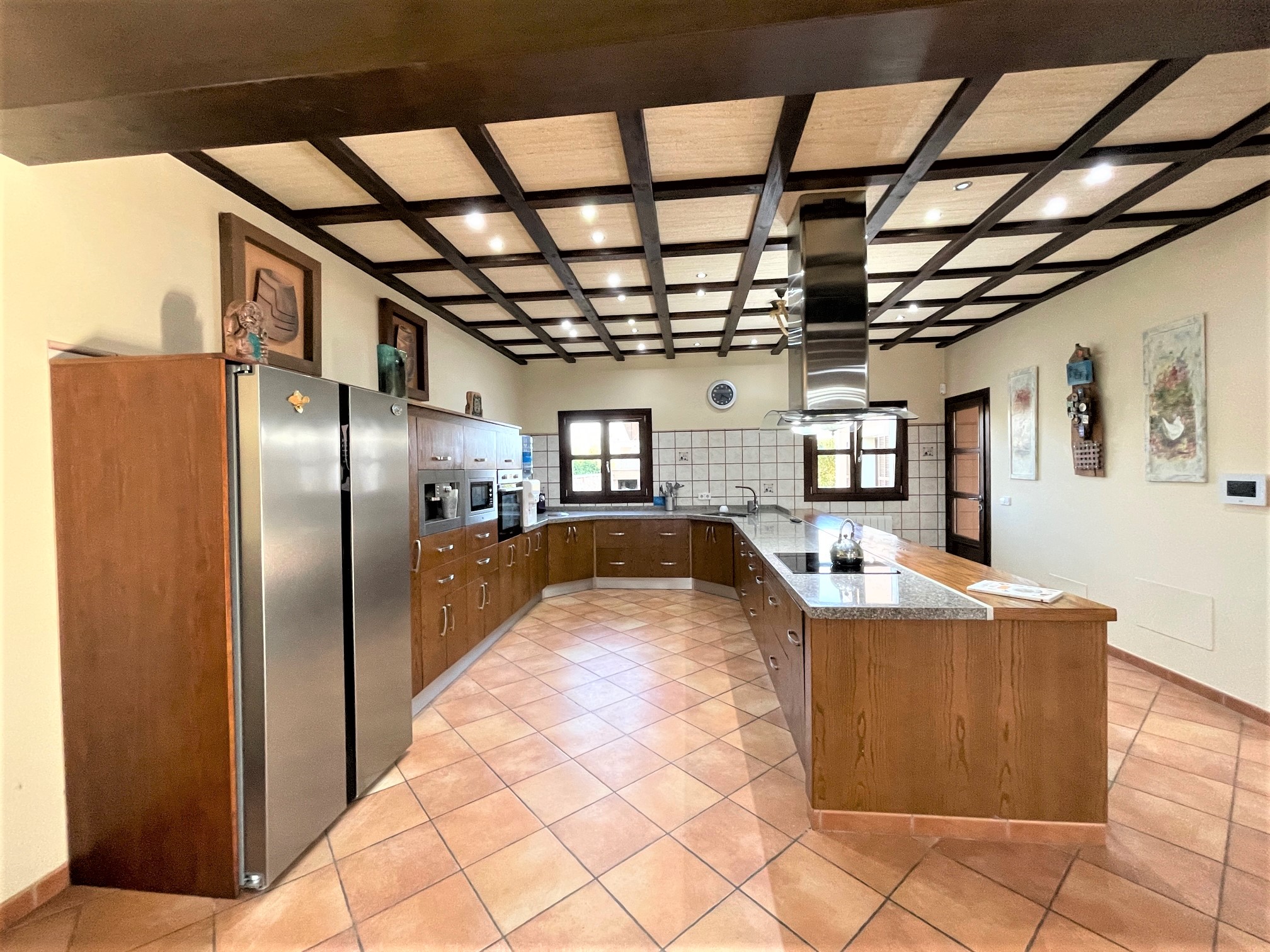 Interior de una vivienda con vigas de madera y cocina abierta