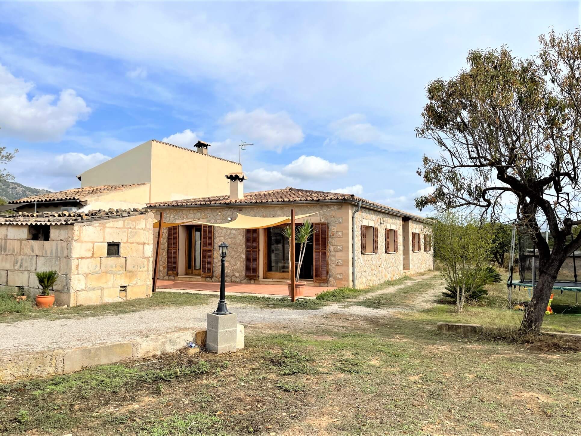 Casa de piedra con porche y jardín, imagen del archivo de HŌM